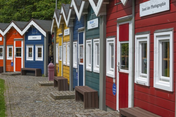 Colourful lobster shacks in the outdoor area of the museum with different themed areas, benches,