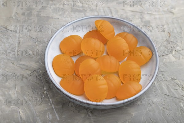 Jelly pumpkin candies on gray concrete background. close up, side view. autumn concept