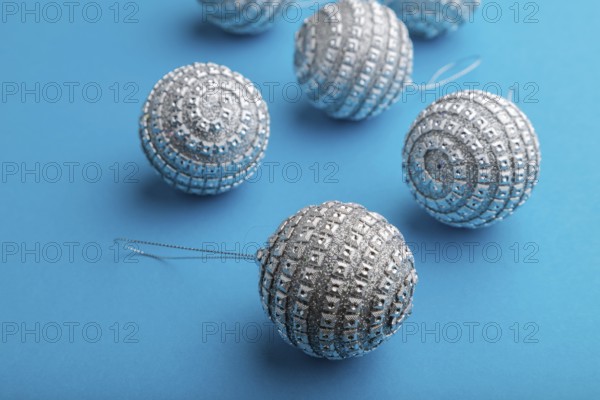 Christmas or New Year composition. Decorations, silver balls, on a blue paper background. Side