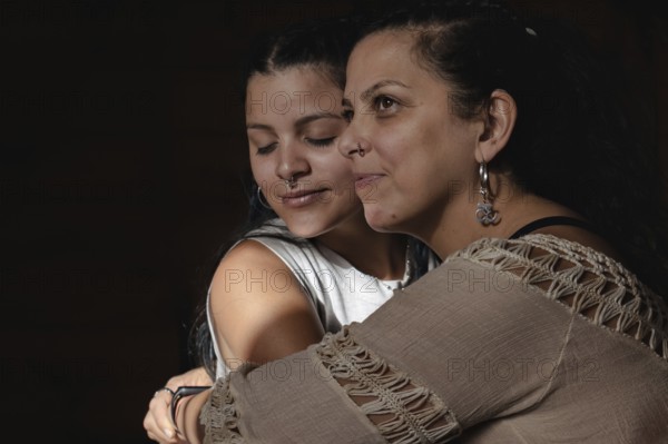 Portrait of deaf Latina mother hugging with young adult daughter