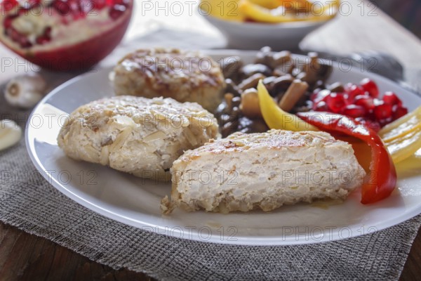 Meatballs with rice mushrooms, sweet peppers and pomegranate seeds on brown wooden background.