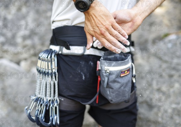 A climber uses so-called chalk (magnesium) in front of climbing a route on the rock, in Morsbach,