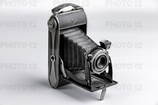 Black bellows camera unfolded on a white background
