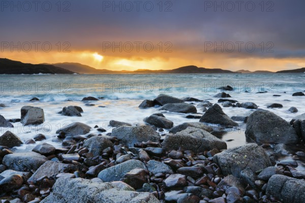 Atmospheric coloured cloudy sky at sunrise on a rocky beach near Reiff on the west coast of