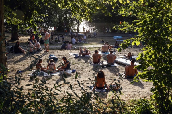 Cooling down at summer temperatures on the shore of the Schlachtensee, Berlin, 11/08/2022