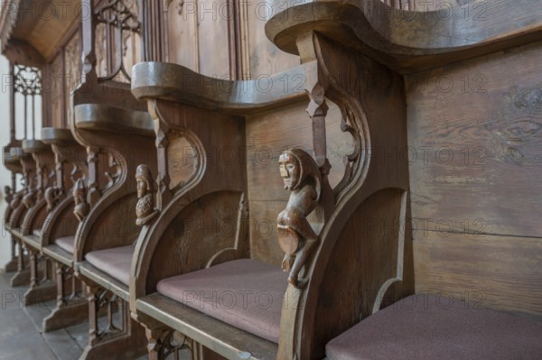 Choir stalls from around 1490 with carved small drolleries and grotesque figures on the chair