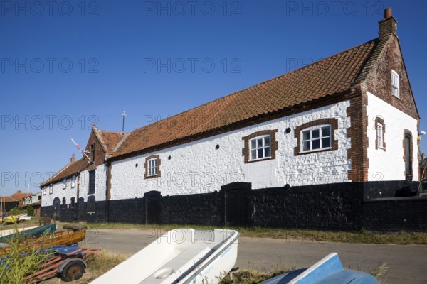 Whitewashed boathouse at the coastal village of Burnham Overy Staithe, north Norfolk coast,