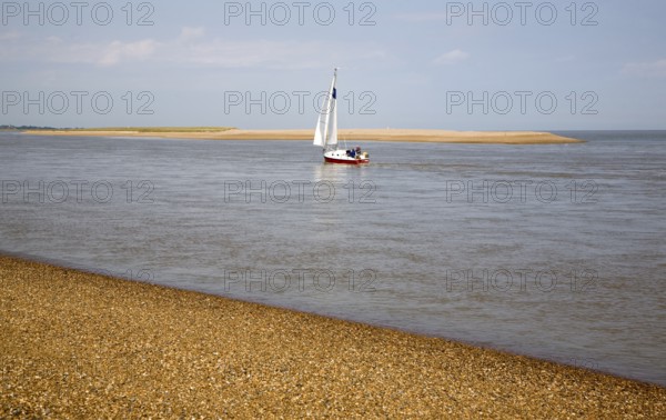 Sailing boat at the mouth of the River Ore at the tip of Orford Ness shingle spit, North Weir