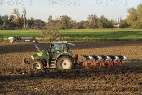 Farmer ploughing a field, tractor with plough, near Neuss, North Rhine-Westphalia, Germany, Europe