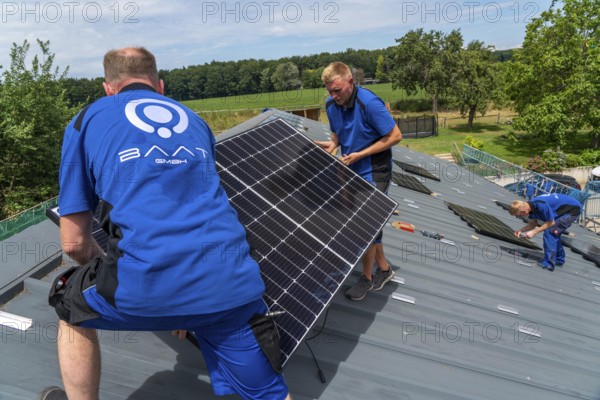 Installation of solar modules on the roof of a barn on a farm, over 240 photovoltaic modules are