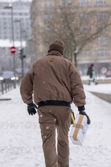 Winter in Frankfurt, UPS employee brings a parcel to a customer, on foot, because of the winter