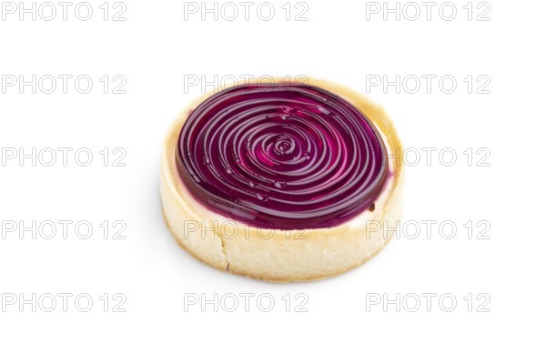 Single sweet tartlet with jelly and milk cream isolated on white background. Side view, close up