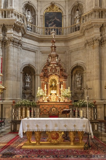 Artistic baroque altar in a church with candles and religious motifs, Granada