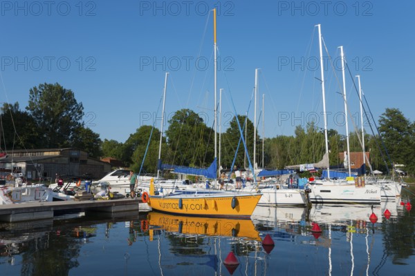 Sailing boats in the harbour with red buoys and a clear blue sky in summer, Gizycko,