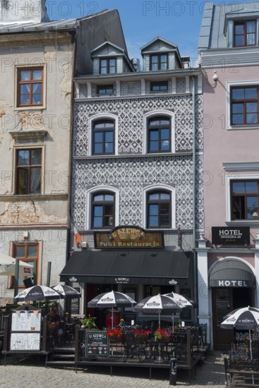 Cosy restaurant in a historic building with a decorative façade and parasols in the city centre,