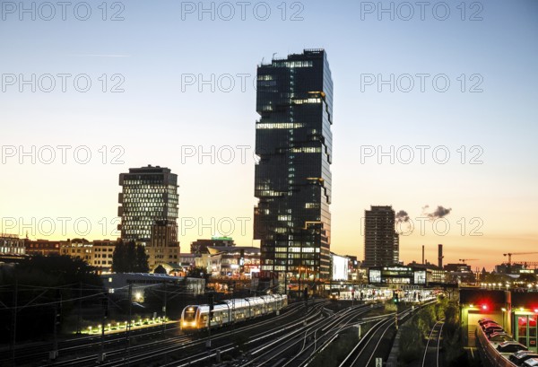 Sunset at the Modersohn Bridge, view of railway tracks, trains and the 140 metre high Amazon office