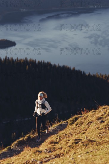 Trail running in autumn on the Jochberg on Lake Walchensee against the wonderful backdrop of the