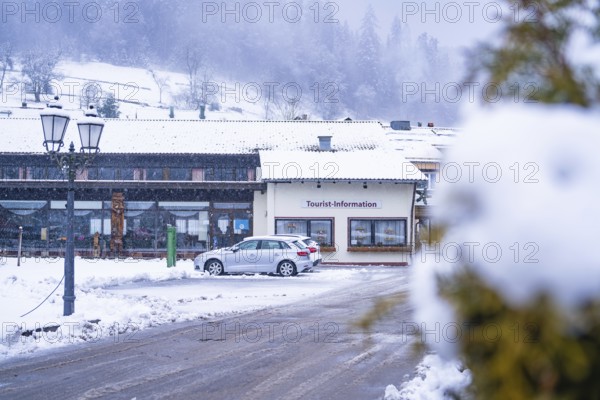 Tourist information centre with parked cars, in front of a snowy mountain scenery, Enzklösterle,