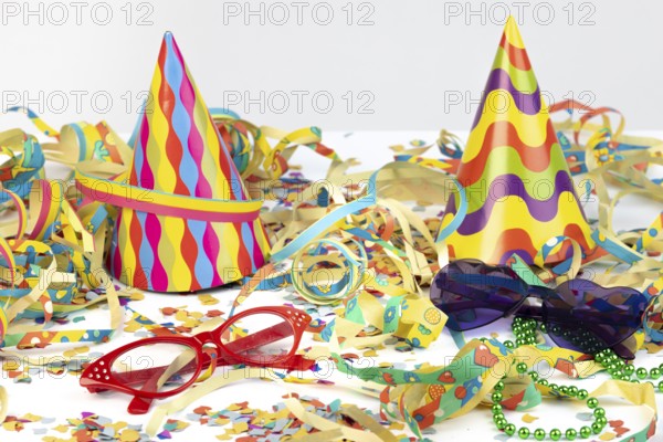 Colourful party hats with glasses and streamers as festive decoration, carnival