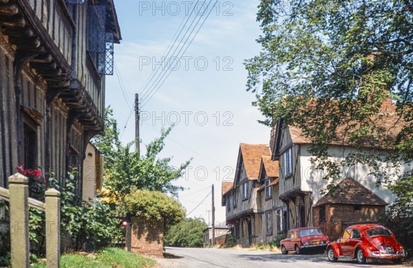 Historische Fachwerkhäuser roter VW-Käfer Volkswagen Auto auf der Straße, Stoke by Nayland,