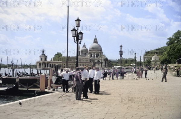 Gondoliers and gondolas, Riva degli Schiavoni, Basilica Santa Maria della Salute, Venice, Italy,
