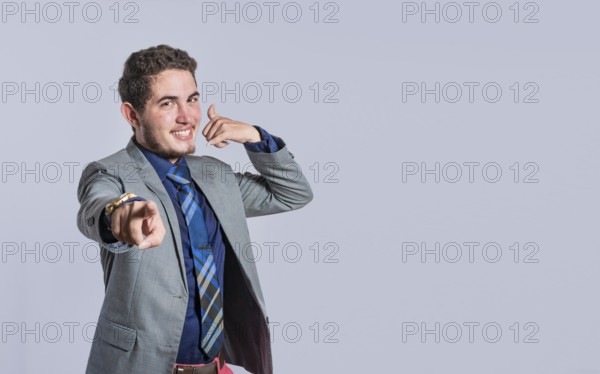 Man making phone gesture with his fingers, Hispanic young man making phone gesture and pointing to
