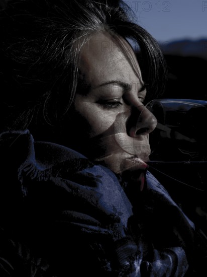 Headshot of a Happy Woman with Sunlight Drinking a Glass of Red Wine in Lugano, Ticino in