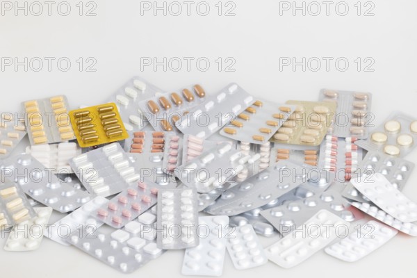 A collection of different medicines in blister packs on a light-coloured background