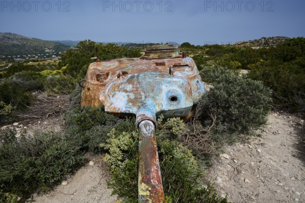 An old, rusty tank lies on a dry, grassy landscape, Anthony Quinn Bay, Vagies Bay, Rhodes,
