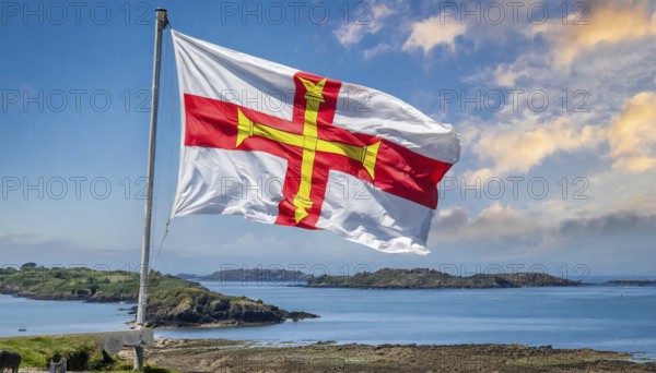 The flag of the Isle of Guernsey, Great Britain, flutters in the wind