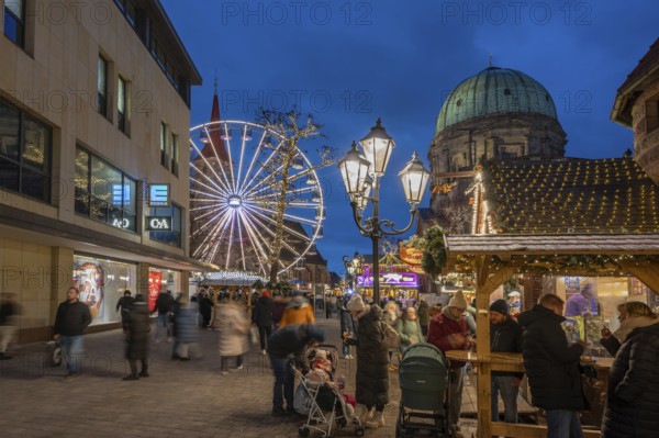 Ferris wheel at the winter village, Christmas market at dusk, St James' Church on the left, St