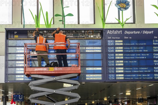 Technicians working on an electronic information board, display board for train connections at