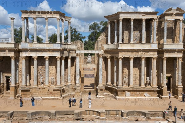 Front view of an ancient Roman building with columns, people exploring the historic site in fine