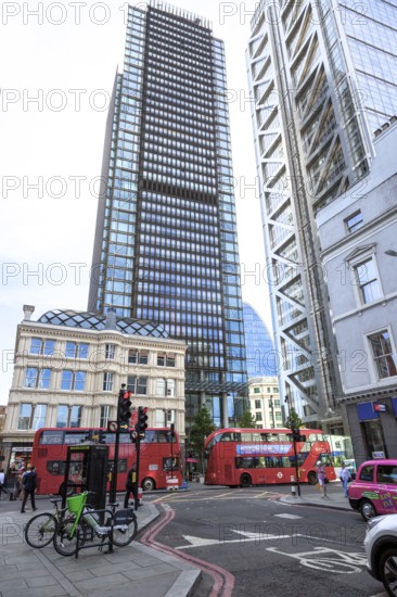 Skyscrapers and red double-decker buses in a busy street scene in the city of London, United