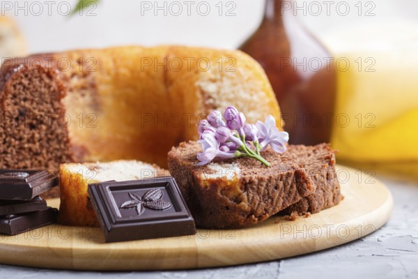 Cakes with raisins and chocolate and a cup of coffee. lilac flowers on a gray concrete background,