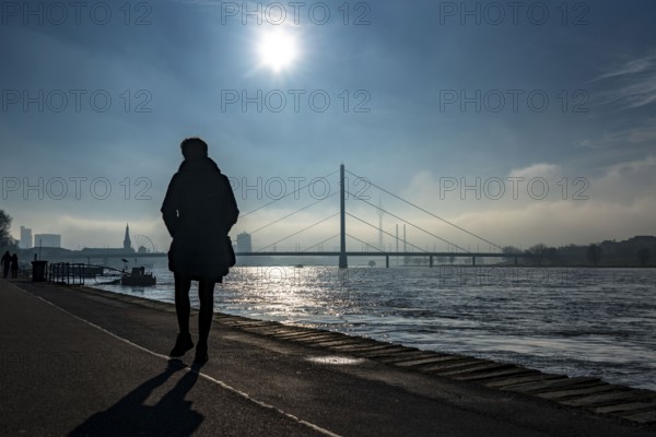 Dense fog is slowly lifting, riverside promenade on the Rhine near Düsseldorf, in front the
