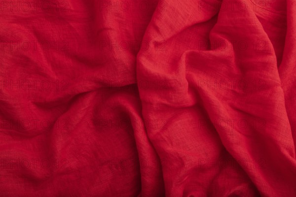 Fragment of red linen tissue. Top view, natural textile background and texture. wave concept,