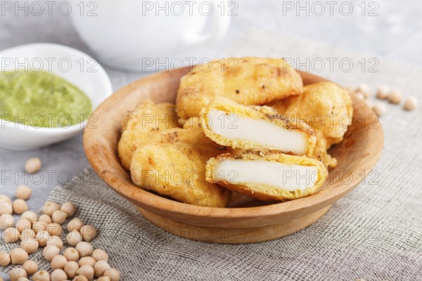 Traditional indian food paneer pakora in wooden plate with mint chutney on a gray concrete