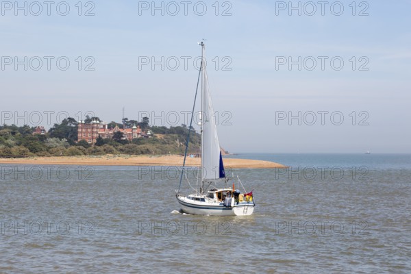Sailing boat yacht in channel at mouth of River Deben estuary view Felixstowe Ferry to Bawdsey