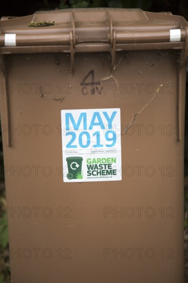 May 2019 date sticker on garden waste scheme brown compost collection bin, East Suffolk, England,