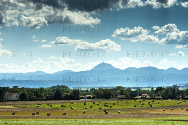 View of the Chain of Volcanoes and Limagne plain under a vibrant sky in Puy-de-Dôme,
