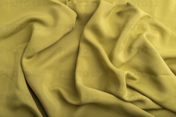 Fragment of green olive silk tissue. Top view, natural textile background and texture. wave