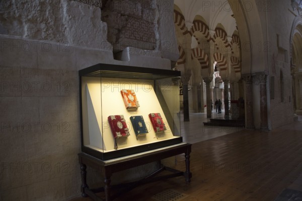 Glass display case of historic bible books inside the cathedral, former Great mosque, Cordoba,