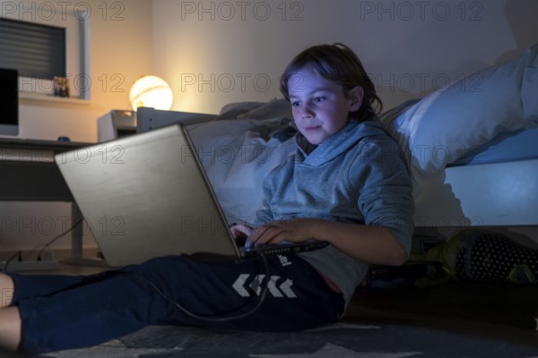 Boy, at home on the computer, laptop, in the children's room, playing a game