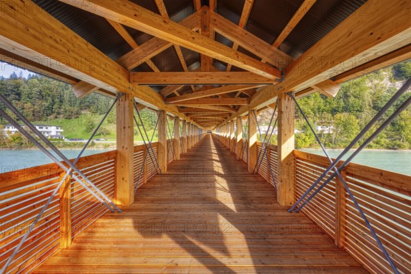 Interior view of a wooden bridge with impressive play of light and shadow and view of the river,