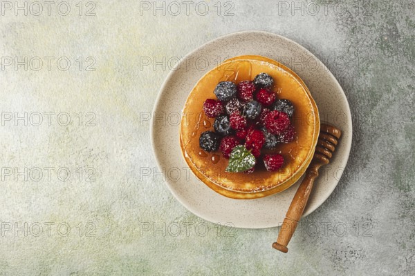 Breakfast, pancakes with berries and honey, top view, homemade, no people