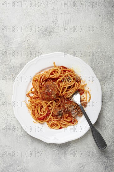 Spaghetti with meatballs in tomato sauce, on a white plate, no people, homemade