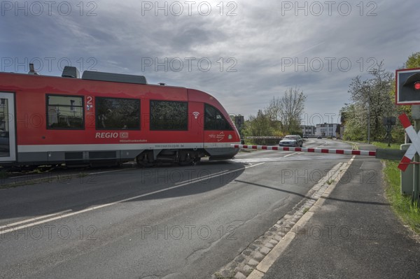 A regional train crosses a level crossing with a barrier, Schnaittach, Middle Franconia, Bavaria,