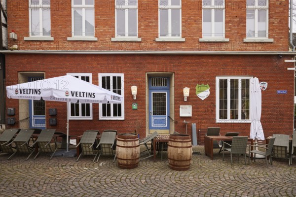 Outdoor area of a catering establishment with old beer barrels as decoration, tables and chairs as