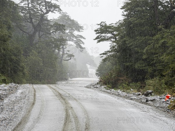 Road Carretera Austral south of village Puyuhuapi, mountain pass, gravel road, snowfall, Patagonia,